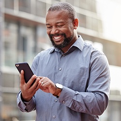 Man walking down street checking his phone