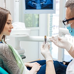 A dentist explaining how implants work to a patient