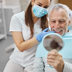 An older man admiring his new dental implants