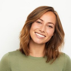 a woman smiling after receiving dental implants in Arlington