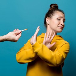 a woman rejecting using a cigarette to protect dental implants