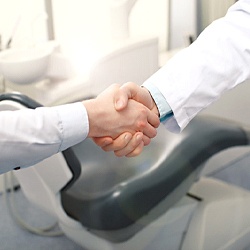 Patient shaking dentist’s hand after wisdom tooth extraction in Arlington, TX