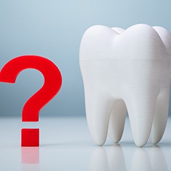 Tooth next to red question mark against neutral background