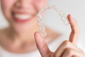 woman holding clear aligner