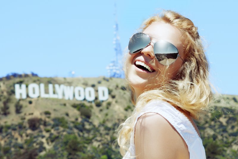 girl smiling in front of the Hollywood sign