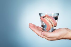 a woman taking her dentures out after a certain amount of time