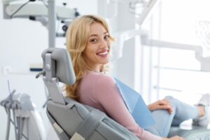 Woman with healthy-looking smile sitting in dentist’s chair.